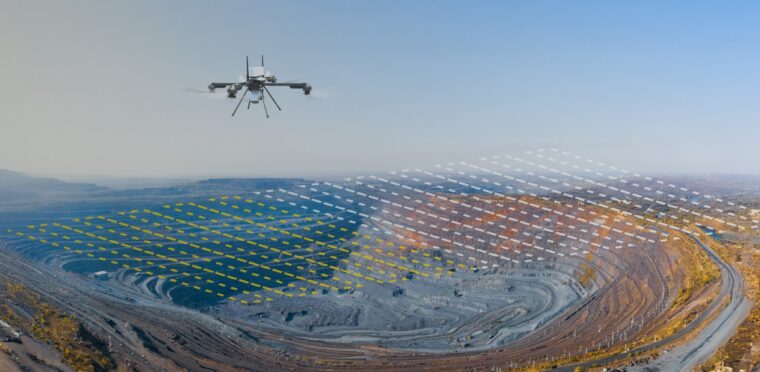 A UAV conducting aerial mapping over a US open-pit mine with visible stockpiles and rugged terrain